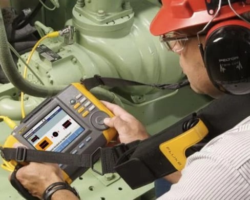 A technician uses the Fluke 810 Vibration Tester. 